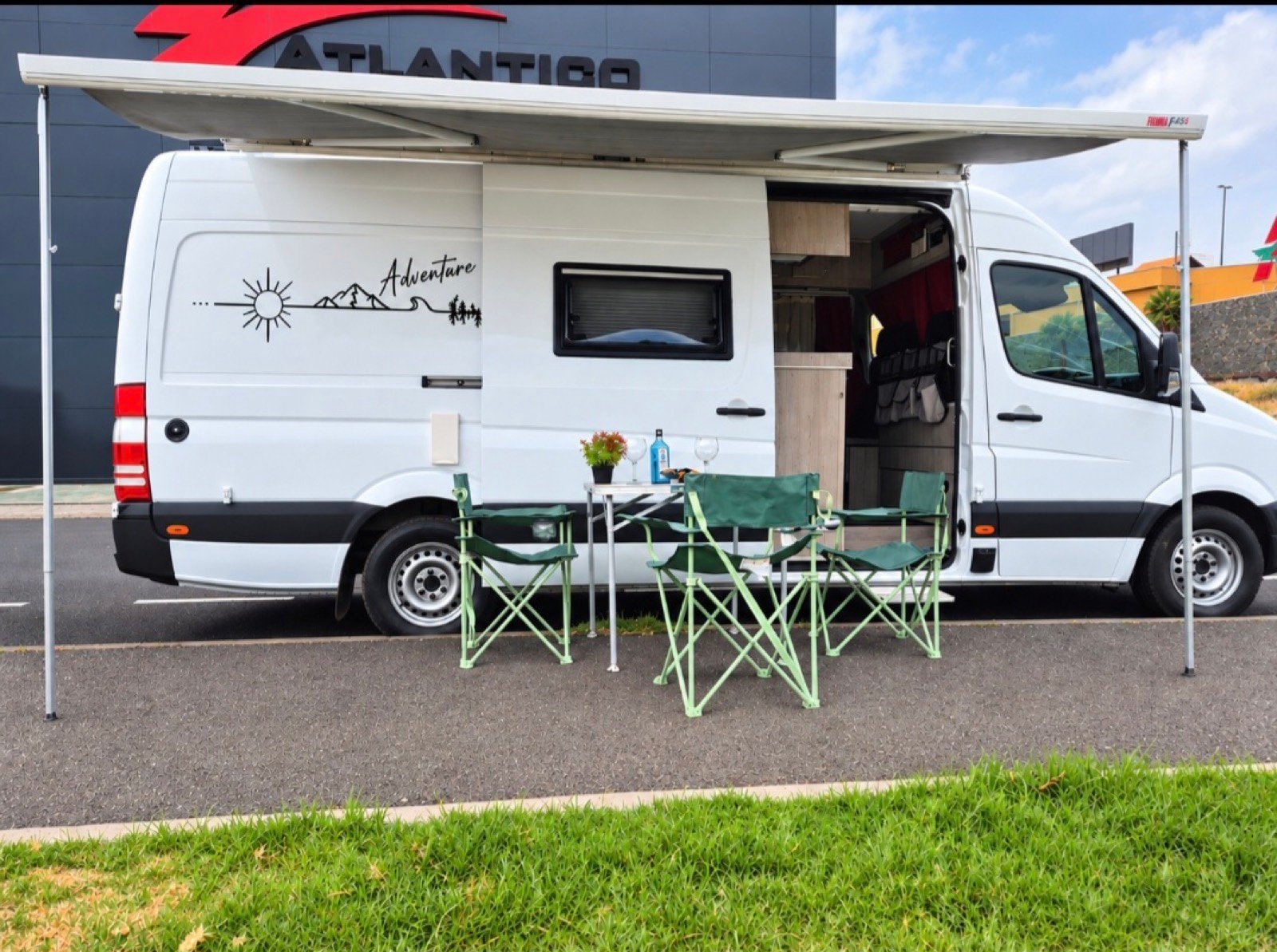 Mercedes Sprinter 313 con el toldo abierto y la mesa con tres sillas montadas